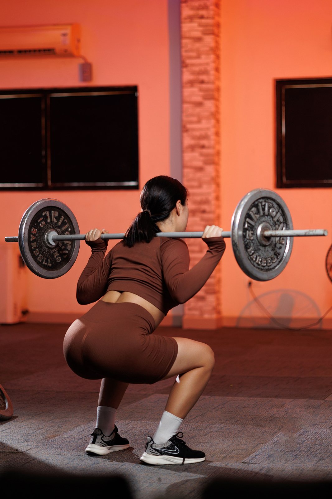 Lifter squatting in raised cushioned running shoes